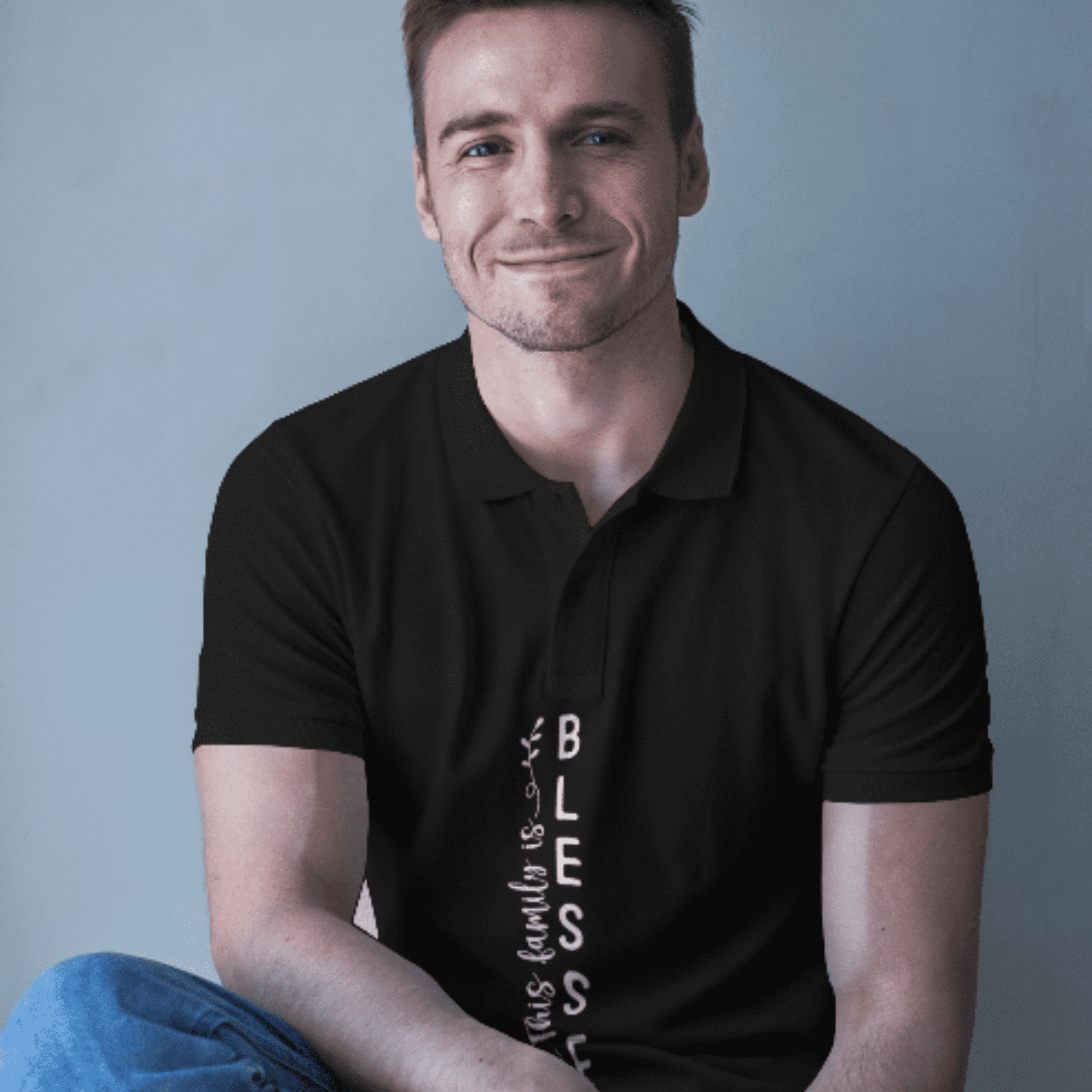 A person wearing a black polo shirt with a vertical graphic on the front that reads "Family is a Blessing."